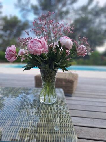 a vase of pink flowers sitting on a table at TINY HOUSE avec piscine "La Bernadette" villa Sisyphe in Le Thoronet