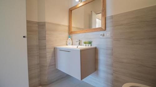 a bathroom with a white sink and a mirror at Corte Coronardi - Elegante casa Campidanese in Quartu SantʼElena