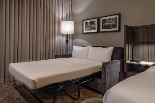 a hotel room with a bed and a chair at The Artisan at Tuscan Village, Salem, NH, a Tribute Portfolio Hotel in Salem