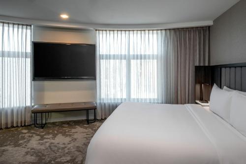 a hotel room with a large bed and a flat screen tv at The Artisan at Tuscan Village, Salem, NH, a Tribute Portfolio Hotel in Salem