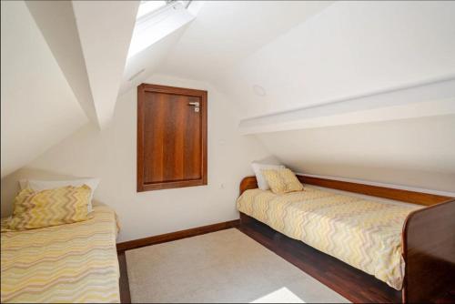 ein kleines Zimmer mit 2 Betten und einem Fenster in der Unterkunft Casa Peixinha in Aveiro