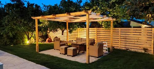 a wooden pergola with a table and chairs under it at Villa Pandesia in Afitos