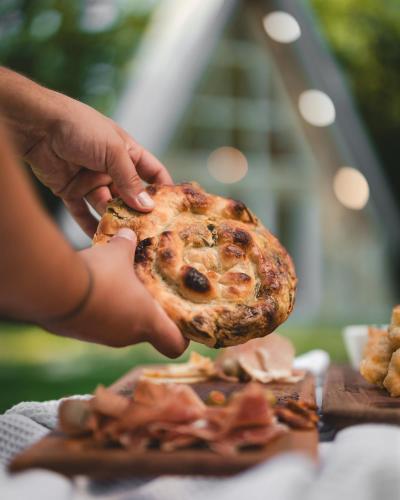 a person is holding a piece of pizza at Vukova dolina apartments in Cetinje