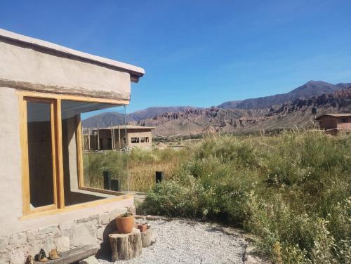 a house in the desert with mountains in the background at Las Ranas in Tilcara