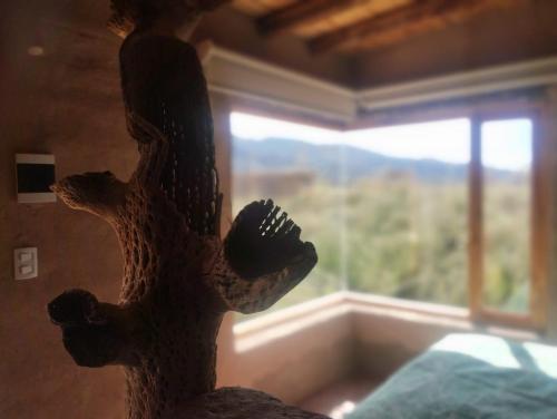 a statue of a dinosaur standing in front of a window at Las Ranas in Tilcara