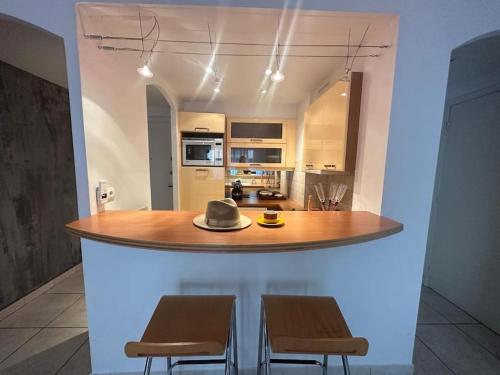 une cuisine avec une table avec deux chaises et un chapeau dessus dans l'établissement Moderne 2pieces proche Martinez, à Cannes