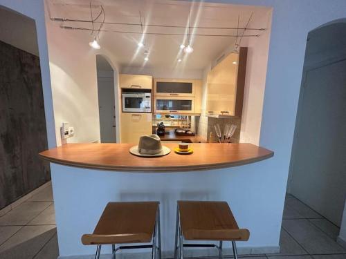 une cuisine avec une table avec deux chaises et un chapeau dessus dans l'établissement Moderne 2pieces proche Martinez, à Cannes