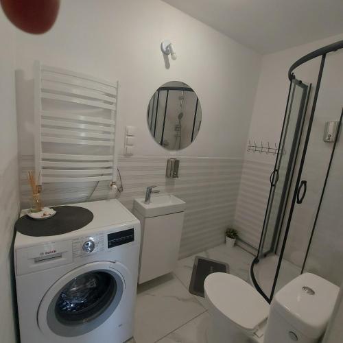 a bathroom with a washing machine and a toilet at Apartament u Krystynki in Kętrzyn
