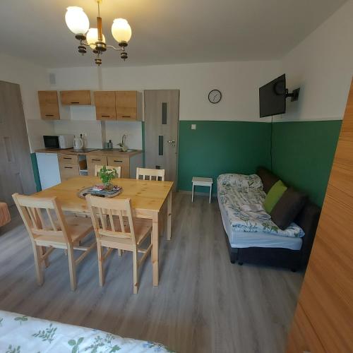 a kitchen and dining room with a table and a couch at Apartament u Krystynki in Kętrzyn