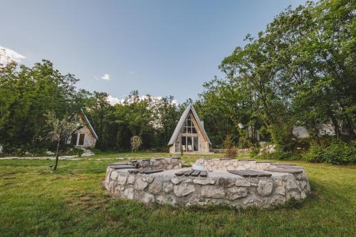 a stone fire pit in front of a cabin at Vukova dolina apartments in Cetinje