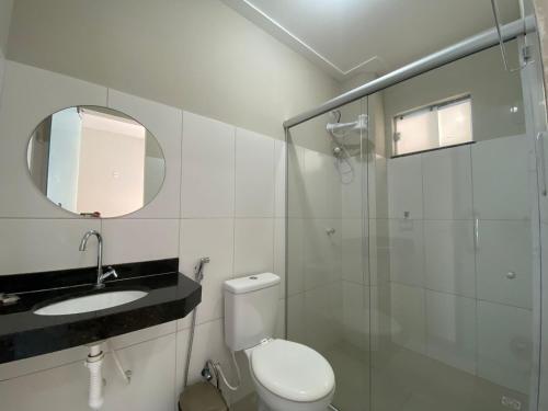 a bathroom with a toilet and a sink and a shower at Guará Praia Hotel in Salinópolis