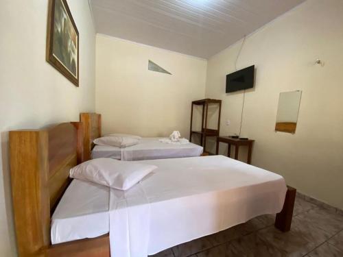 a room with two beds and a television in it at Guará Praia Hotel in Salinópolis
