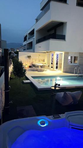 a swimming pool in front of a house at Luxury apartment Black Pearl Beluga with private Pool and Jacuzzi in Novalja