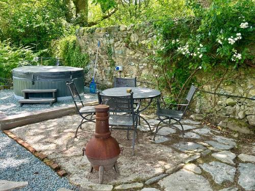 a patio with a table and chairs and a fire hydrant at Tiny Romantic Retreat with Hot Tub on a Country Estate near Cardigan Bay in Eryri Snowdonia in Llanbedr