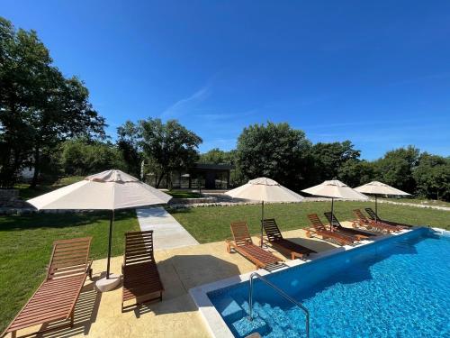 a group of chairs and umbrellas next to a pool at KOKO VILLAGE in Podgorica
