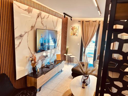 テッサロニキにあるM Boutique Apartmentsの壁にテレビが取り付けられたリビングルーム