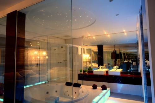 a bathroom with a bath tub and a mirror at Petaluma hotel Fomiga in Formiga