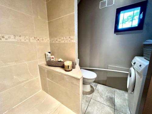 a bathroom with a toilet and a window at Ty Kerrian, maison avec jardin à la campagne in Locunolé