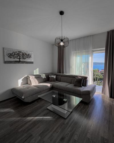 a living room with a couch and a glass table at Apartman Dora in Crikvenica