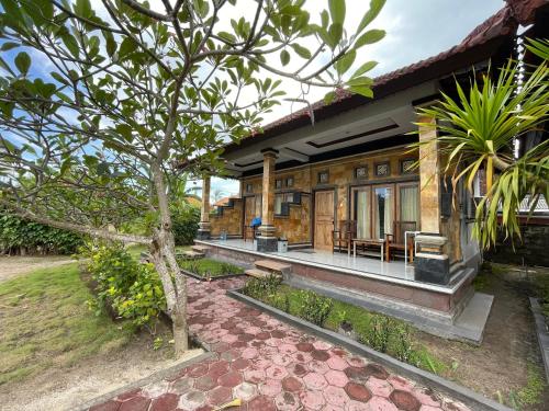 a house with a patio and a tree at Jepun Bali Bungalow in Nusa Lembongan
