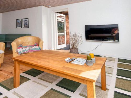 a living room with a wooden table and a television at 5 person holiday home in Skjern-By Traum in Skjern