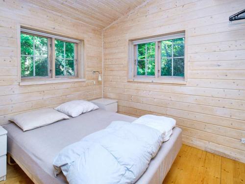 1 Schlafzimmer mit 2 Betten an einer Holzwand in der Unterkunft 7 person holiday home in Hornbæk-By Traum in Hornbæk