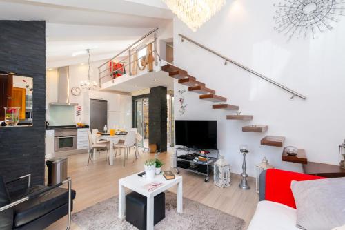 a living room with a staircase and a kitchen at White & Grey House in Tavira