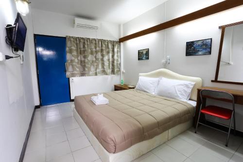 ein Schlafzimmer mit einem großen Bett und einem roten Stuhl in der Unterkunft Chomdoi House Hotel in Chiang Mai