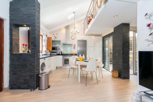 a kitchen and dining room with a table and chairs at White & Grey House in Tavira