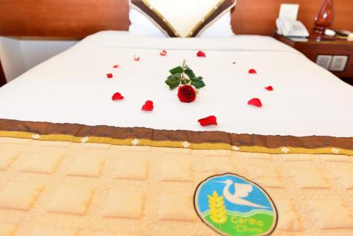a cake on a bed with roses on it at Hau Giang Hotel in Can Tho