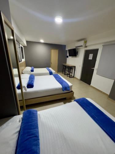 a hotel room with two beds and a flat screen tv at HOTEL MEDELLIN CENTRAL in Medellín