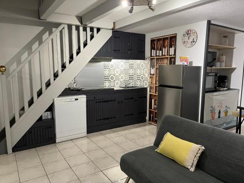 une cuisine avec un canapé et une cuisine avec un escalier dans l'établissement La Casita à la mer de Lili, à Gruissan