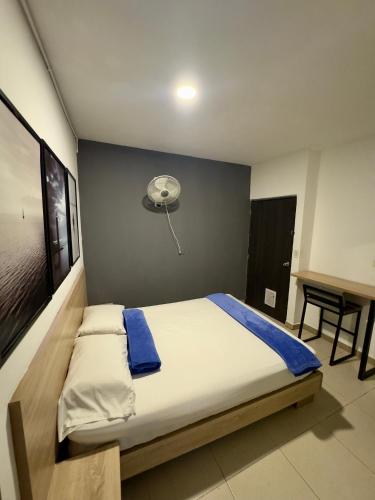 a bedroom with a bed with a fan and a desk at HOTEL MEDELLIN CENTRAL in Medellín