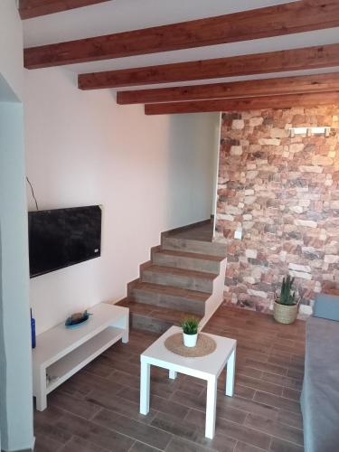 a living room with a staircase and a stone wall at Poril in Gran Tarajal
