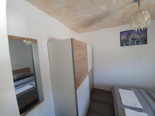 a small bedroom with a mirror and a bed at 6 M, 50 m do plaže in Barbat na Rabu