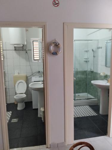 a bathroom with a toilet and a sink and a shower at 6 M, 50 m do plaže in Barbat na Rabu