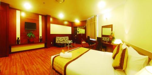 a hotel room with a bed and a living room at Hau Giang Hotel in Can Tho