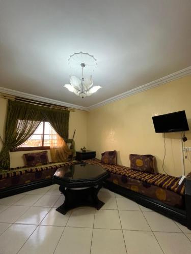 a large living room with a couch and a table at Appartement deux chambres in Berkane