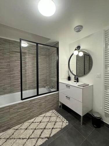 une salle de bain avec un lavabo et un miroir dans l'établissement Le Riviera Near Disneyland Paris, à Chessy