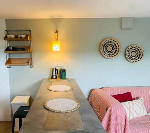 un salon avec une table et un canapé dans l'établissement Appartement déco avec jardin et piscine, à Chambéry