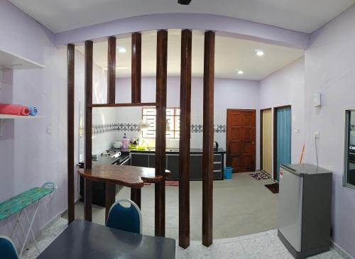 a kitchen with a wooden table in a room at Liya's Homestay in Kangar