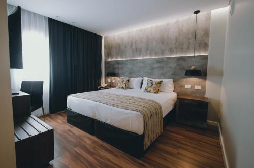 a hotel room with a large bed and a large window at Uthgra Presidente Perón in Mar del Plata