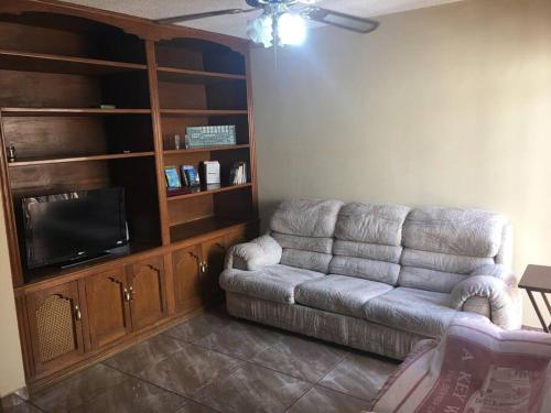 a living room with a couch and a flat screen tv at Casa muy comoda en excelente lugar in Hermosillo