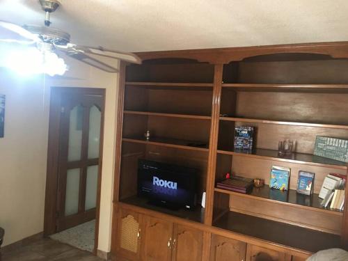 a room with a wooden book shelf with a tv at Casa muy comoda en excelente lugar in Hermosillo