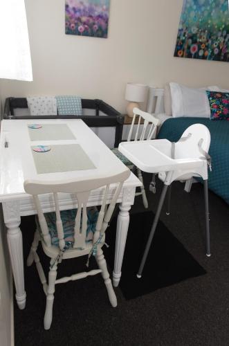 a room with two white tables and chairs and a bed at Hopwood Bed & Breakfast in Taihape