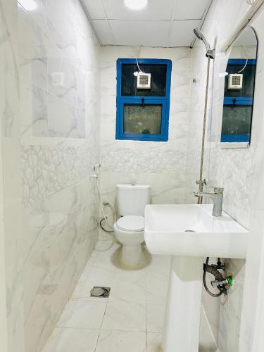 a white bathroom with a sink and a toilet at Feel like a home away home in Ajman