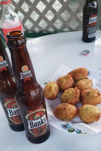 two bottles of beer and a plate of food at T.Cole’s Holiday Rental in Saint James