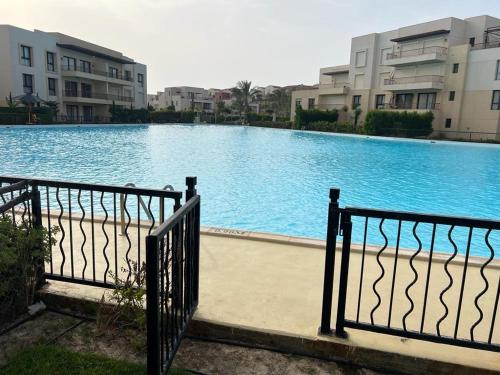 a large swimming pool in front of some buildings at Ground chalet 2 bedrooms blanca marassi Direct to lagoon in El Alamein