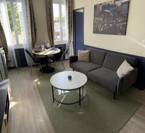 un salon avec un canapé et une table dans l'établissement Appartement tout confort, à Rouen
