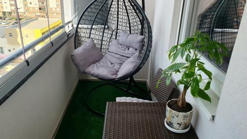 a porch with a hammock on a balcony with a plant at Istocno Sarajevo, Lukavica, Great View Apartment in Donje Mladice